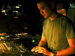 Satoshi Tomiie playing in front of a mixer and cd players