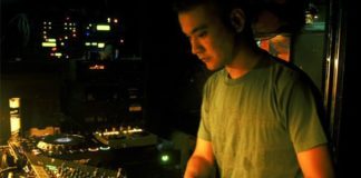 Satoshi Tomiie playing in front of a mixer and cd players