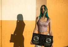 O artista tine o consola pentru mixat in dreptul coapselor