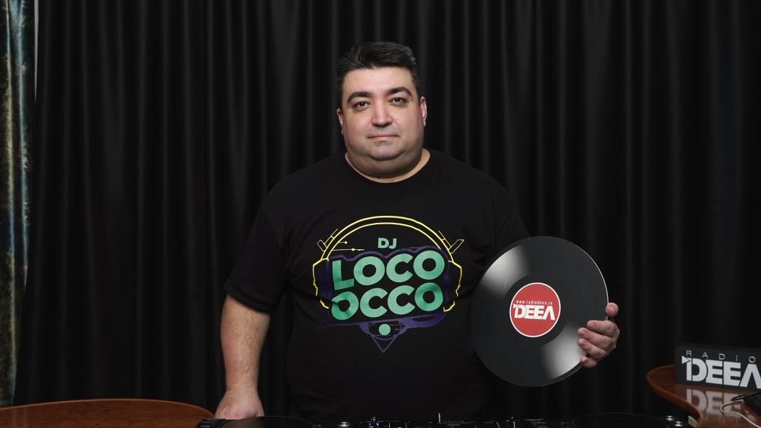 DJ Loco oCco in spatele pupitrului cu playere de la Radio DEEA cu un disc pe care se poate citi radio deea in mana stanga - partea dreapta a fotografiei