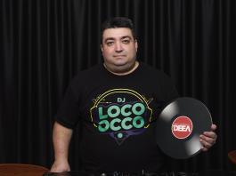 DJ Loco oCco in spatele pupitrului cu playere de la Radio DEEA cu un disc pe care se poate citi radio deea in mana stanga - partea dreapta a fotografiei